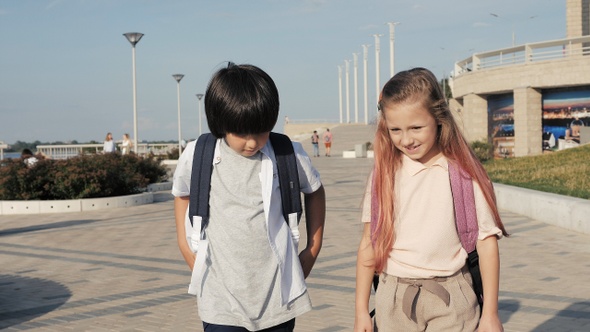 Schoolchildren with backpacks walking and having fun alt