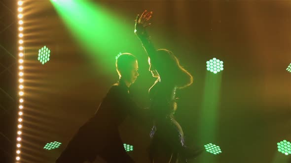 A Slender Brunette with Long Hair is Dancing the Chachacha with Her Partner alt