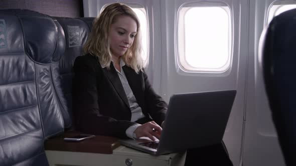 Businesswoman using laptop computer on airplane