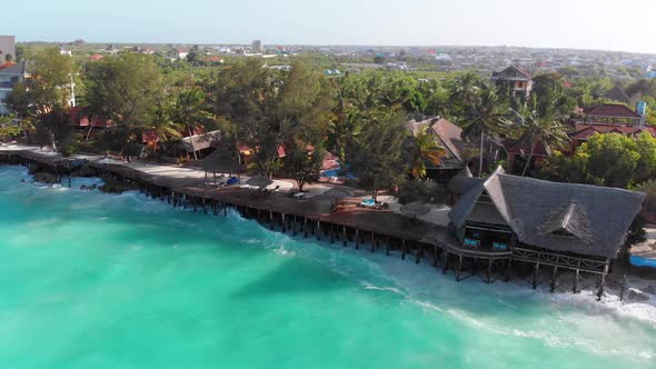 Aerial Tropical Landscape of Zanzibar Waves Hit Reef on Hotels Coastline Palms alt