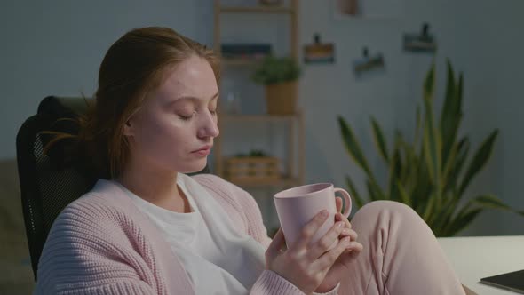 Tired Female Designer Drinking From a Cup alt