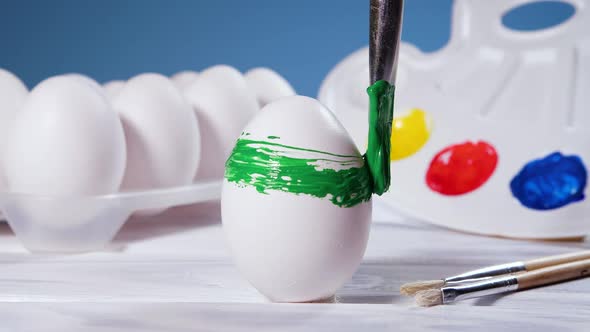 Painting Easter Eggs with a Green Brush Preparation for Spring Holiday Religious Celebration Art alt