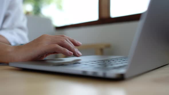 Closeup a woman working and touching on laptop computer touchpad on the table