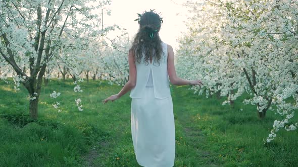 girl walking on a blooming garden and resting alt