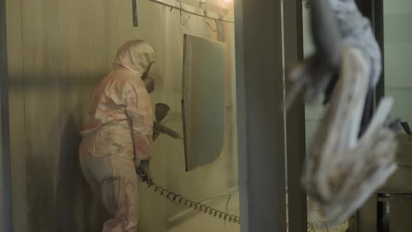 Worker in Protective Suit Sprays Powder Paint From Gun on Metal Products