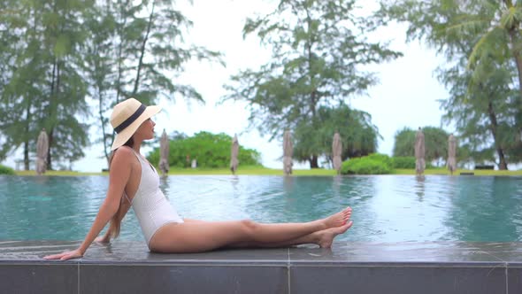 Young asian woman enjoy around outdoor swimming pool for leisure