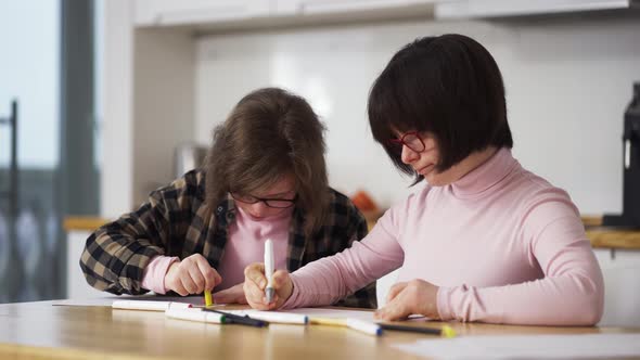 Two Girls Draw with Colorful Pens at Home alt