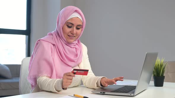 Muslim Woman Wearing Hijab Using Laptop for Online Shopping at Office alt
