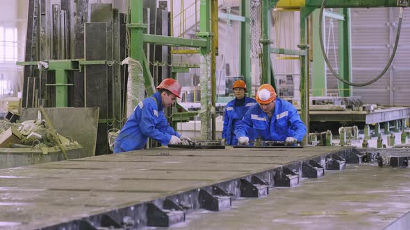 Workers leveling cement to forms