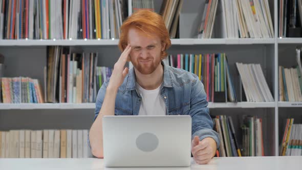 Upset Man Working on Laptop in Library alt