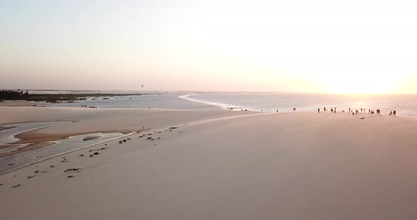 Aerial drone view of a group of people crowd on a sand dune at the beach alt