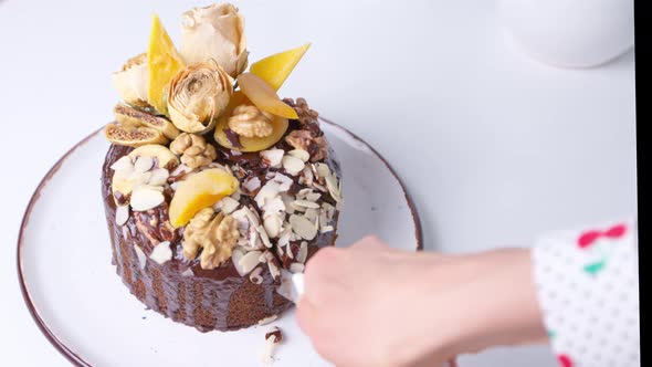 Woman baker pastry chef cuts a chocolate muffin with a knife. Easter bread. 4K. alt