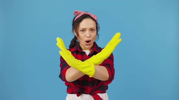Emotional Housewife in Rubber Gloves Crossing Hands in Rejection Blue Studio Background alt