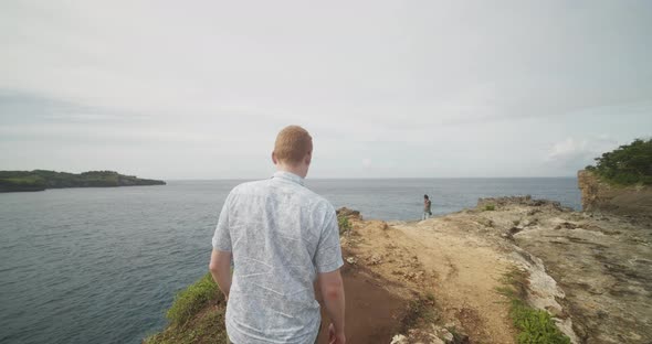Dolly Following Shot of Man with Ginger Hair Walking on the Cliff By the Ocean Near Famous Broken alt