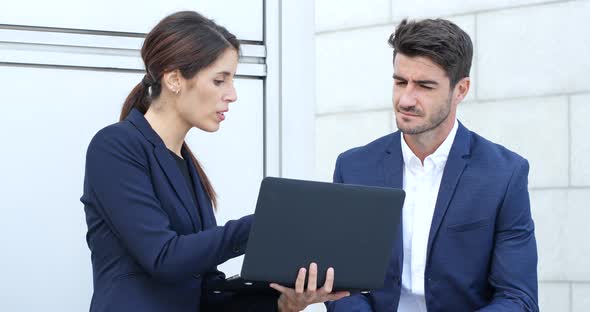 Business People Looking at Laptop Computer and Discuss