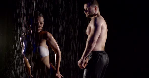 Half Naked Man and Woman Are Under Streams of Water in Dark Studio alt