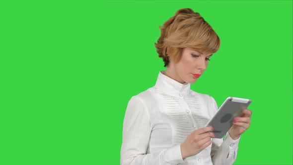 Young Woman Using a Tablet on a Green Screen, Chroma Key alt