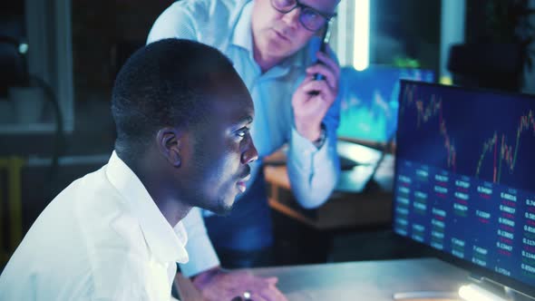 Two Brokers are Analyzing Stock Market Reports alt