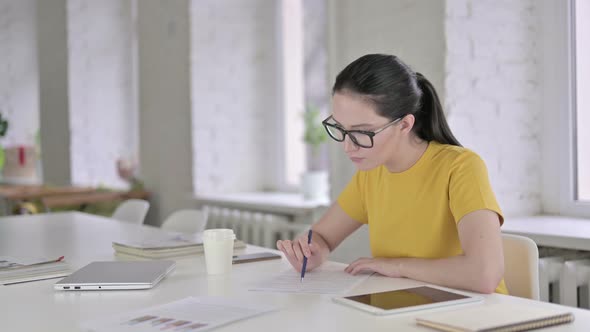 Ambitious Young Female Designer Writing on Papers in Office alt