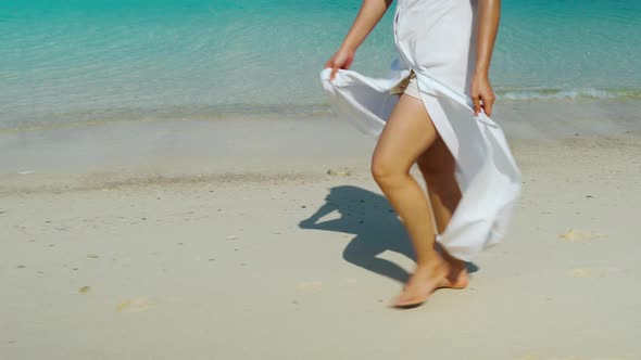 woman legs walking on the sea beach at Koh MunNork Island, Rayong, Thailand alt