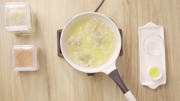 Frying Moroccan Briwat in white pot with burning oil, top shot static. alt