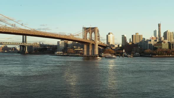 Low Flight Above Water Cruise Ship Floating on Surface Under Brooklyn Bridge alt