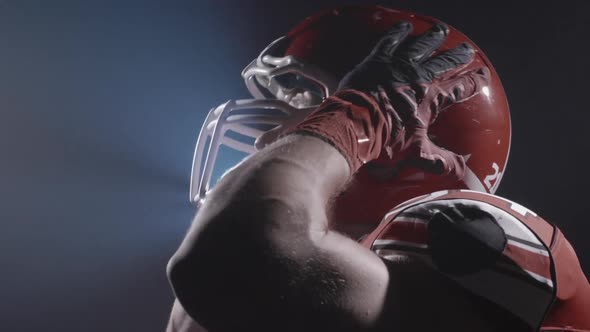 Portrait of Determined Professional American Football Player in Helmet in Bright Stadium alt
