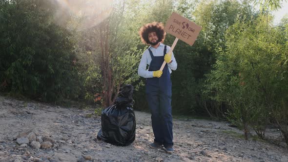 Portrait of Multiracial Guy Eco Volunteer Looking To Camera While Holding Carton Placard with Save alt