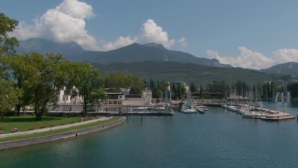 Beautiful drone shot of the marina in Riva Del Garda with the gardalake in the foreground and the it alt