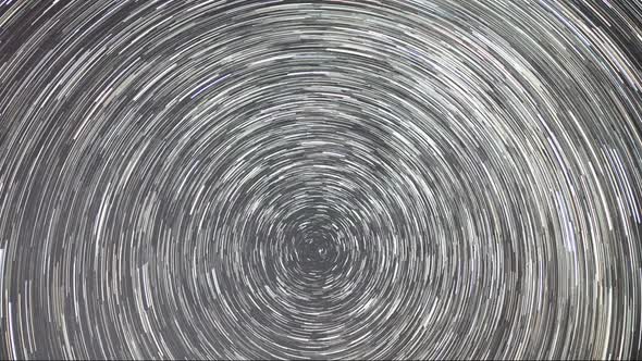 Timelapse of moving star trails in night sky. The Milky Way galaxy rotating alt
