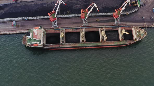 Bulk Carrier is Loaded with Coal in the Port Using Cranes alt