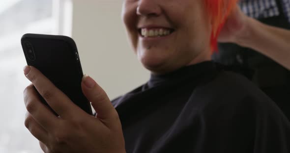 Front view happy woman looking at her phone alt