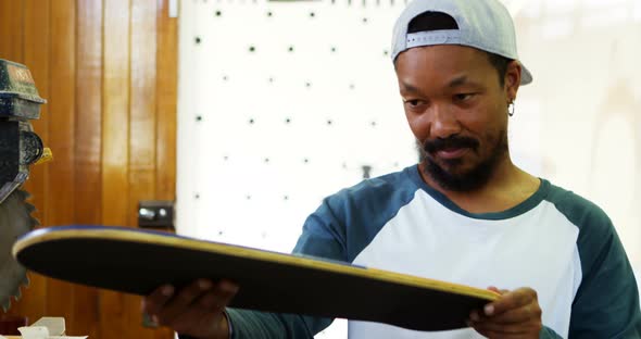 Man looking at skateboard  alt