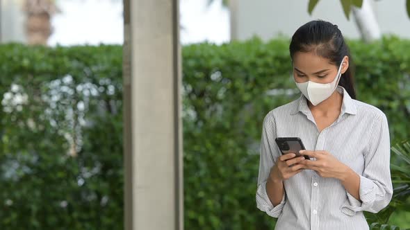 Woman Wearing Face Mask to Protect From Coronavirus Covid19 While Using Phone and Taking Selfie