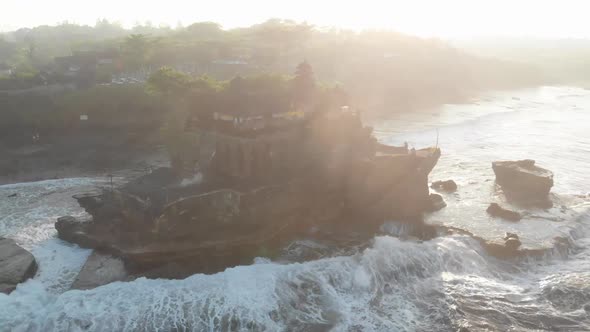 The sun dazzles the drone pickup over a Temple in Bali Indonesia