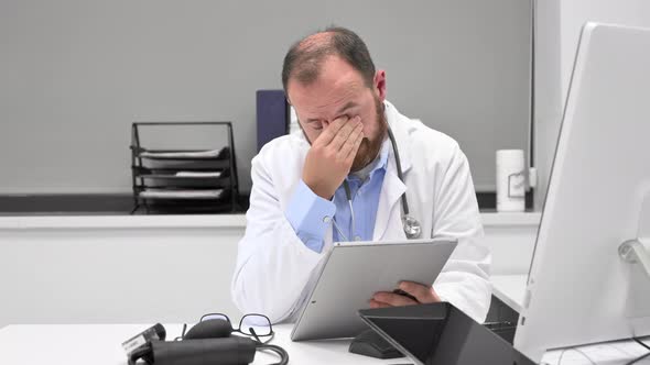 Doctor Looking Worried a Xray Image at Digital Tablet Checking the Results of a Medical Examination alt