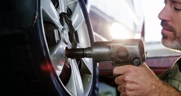 Mechanic fixing a car wheel alt
