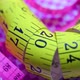 Close Up of a Pink and Yellow Measure Tape on Colored Rotating Background - VideoHive Item for Sale