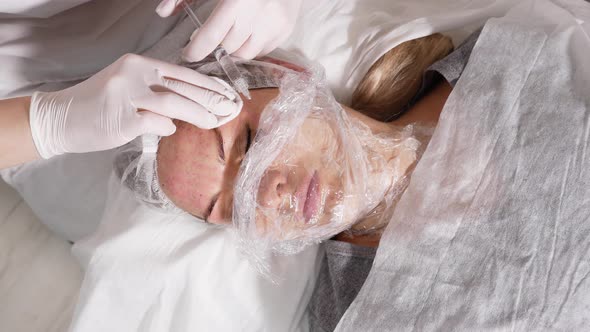 Doctor Beautician Pricks the Patient's Face