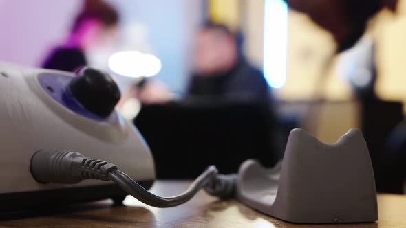 Hardware Manicure in the Nail Salon - a Person Takes a Small Nail Grinder Machine From the Table alt