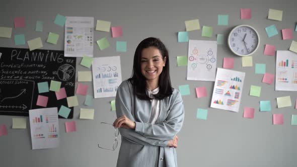 Front view of beautiful young female professional administrator looking to camera and smiling alt