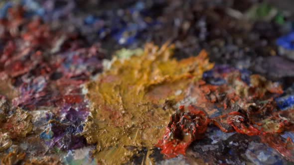 Extreme close-up dolly out over artwork with textured paint, artist workshop alt