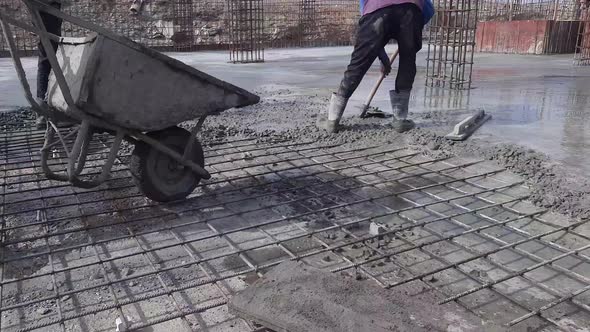 A construction worker Concrete slab being cast by wheelbarrow or concrete trolley. Construction work alt