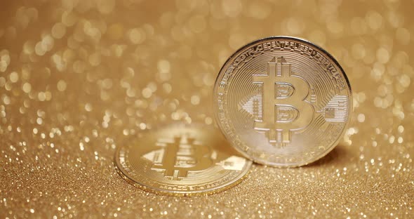 Close Up on gold background with bokeh. Bitcoin BTC coin. New virtual currency. alt