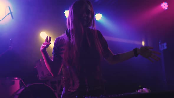 Beautiful Young Woman DJ Play the Music on the Mixing Console in the Nightclub alt