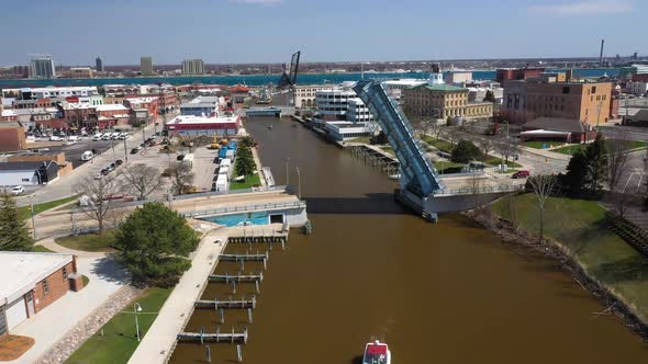 Boat on river with drawbridge open on the Black River in Port Huron, Michigan with drone videoing fo alt