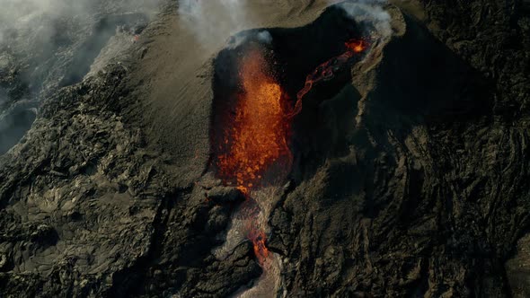 Spectacular aerial top down of lava spewing from an active erupting volcano during daytime. alt