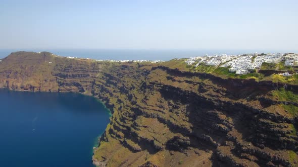 Santorini cliffs with white cave hotels aerial view