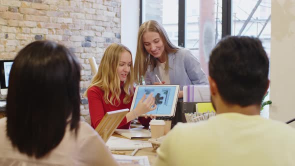 Female Designers Showing Interior on Tablet to Clients