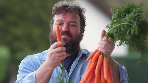 Happy farmer or seller with bunch of fresh carrots